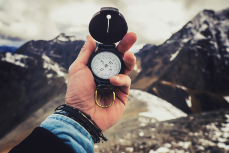 Persona orientándose con una brújula en la montaña