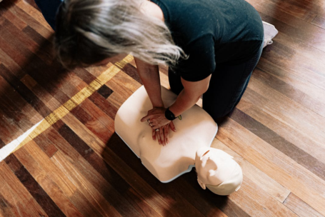 Mujer haciendo reanimación a maniquí